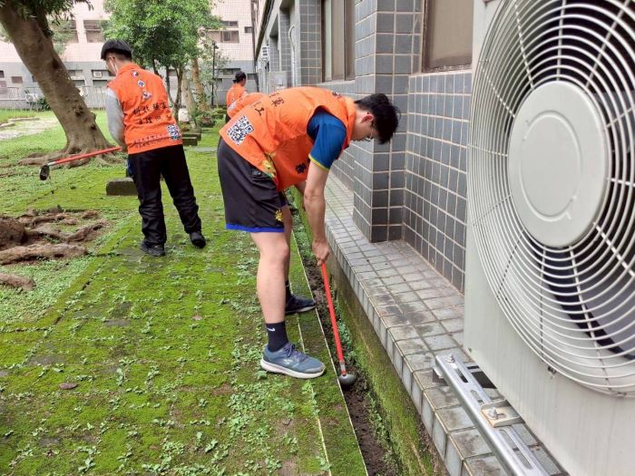 《圖說》國防大學師生組成志工團走進八德榮家，主動投入各項服務工作，手持工具細心清理排水溝及周邊環境，展現青年學子熱心服務與無私奉獻的精神。〈八德榮家提供〉