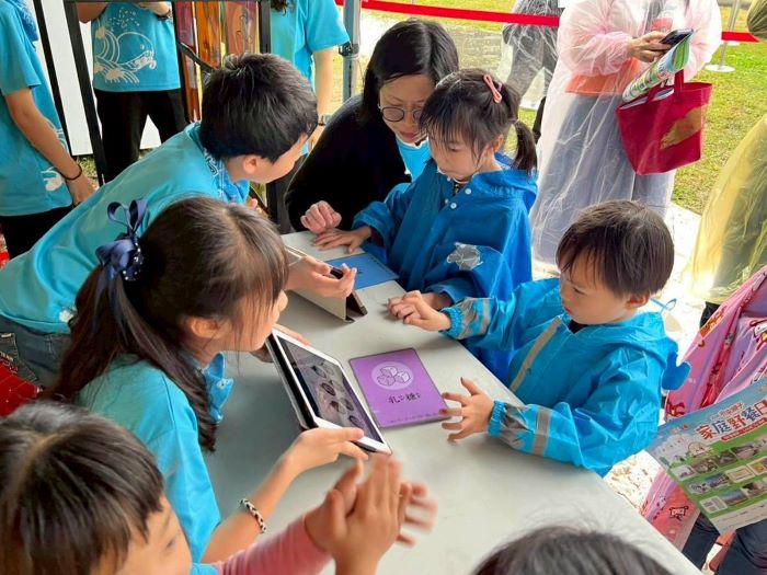 《圖說》牛奶攤熱情的小志工與民眾親切互動，讓服務的喜悅在攤位間流動。〈教育局提供〉