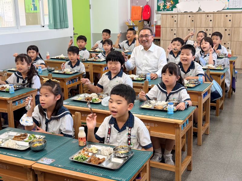 《圖說》市長侯友宜開學日特別走進校園關心供餐情形，與學童一同用餐，品嘗融入在地食材的特。〈教育局提供〉